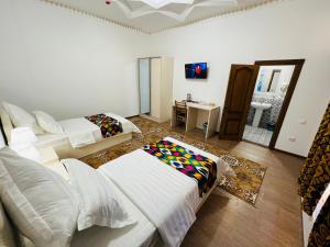 een woonkamer met 2 bedden en een wastafel bij Lola Boutique Hotel in Bukhara
