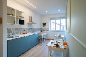 a kitchen with blue cabinets and a small table at La dolce vita rooms in Rome