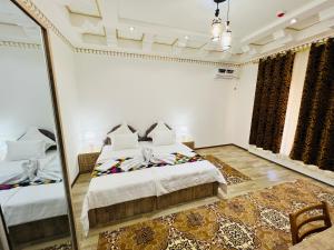 een slaapkamer met een bed en een spiegel bij Lola Boutique Hotel in Bukhara