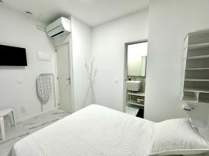 a white bedroom with a bed and a sink at Alcalá Retreat: Ocean View & Modern Comfort in Alcalá