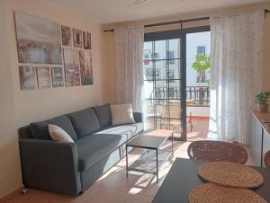 a living room with a couch and a large window at Greatly located apartment with heated pool, Los Cristianos in Los Cristianos