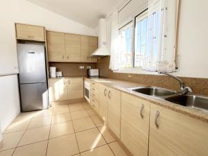 a kitchen with a sink and a stainless steel refrigerator at Villa Ariana in L'Ametlla de Mar