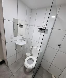 La salle de bains blanche est pourvue de toilettes et d'un lavabo. dans l'établissement Solares le Bardot, à Búzios