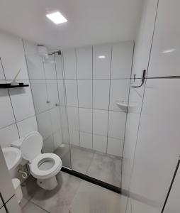 La salle de bains blanche est pourvue d'une douche et de toilettes. dans l'établissement Solares le Bardot, à Búzios