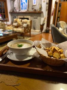 eine Schüssel Suppe und ein Korb Brot auf einem Tablett in der Unterkunft Ville de France in Campos do Jordão