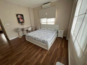 1 dormitorio con 1 cama y suelo de madera en Amy's house独栋别墅,近机场,四晚接送机 en Bangkok