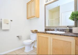 a bathroom with a toilet and a sink and a mirror at Amazing Lil Italy 2bdr Home Dtla in Los Angeles