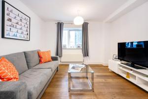a living room with a couch and a flat screen tv at Welcome London - New Oxford Street in London