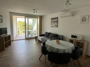 salon z kanapą i stołem w obiekcie Apartments Amore w Bašce