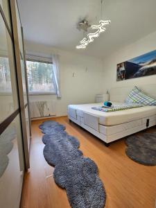 a bedroom with a bed and a row of rugs at Ferienwohnung - Apartment Pichlarn Holiday in Aigen im Ennstal