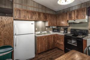 a kitchen with a white refrigerator and wooden cabinets at Sacony, Cabin at Ruidoso in Ruidoso