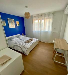 ein Schlafzimmer mit einem Bett und einer blauen Wand in der Unterkunft La paillote marseillaise in Marseille