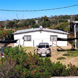 a car parked in front of a white building at La casa de Juan in Cuchilla Alta +27 photos