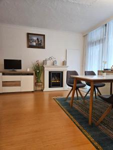 sala de estar con mesa y chimenea en Ferienwohnung - Apartment Pichlarn Holiday, en Aigen im Ennstal