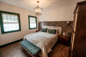 a bedroom with a large bed and a chandelier at Pousada Boutique Villa Chafariz Tiradentes in Tiradentes