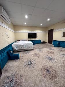a room with a bed and a couch and a tv at استديو البركه-Al Baraka Studio in Umm Lajj