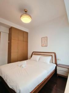 a bedroom with a large white bed with a light at F13 R&F 2BR Swimming Pool @ CIQ in Johor Bahru