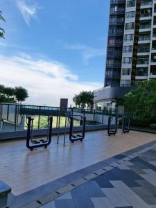 a row of benches on a sidewalk in a city at F13 R&F 2BR Swimming Pool @ CIQ in Johor Bahru