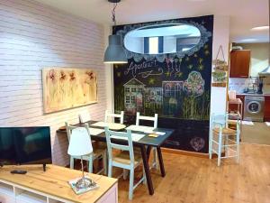 une salle à manger avec une table et des chaises blanches dans l'établissement Logrocity Corazon de Logroño parking privado gratis, à Logroño