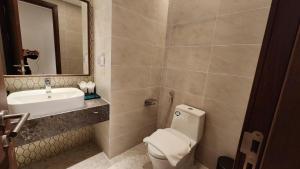ein Badezimmer mit Toilette, Waschbecken und Spiegel in der Unterkunft APEC Mandala Mũi Né Condotel in Ấp Thiẹn Ái
