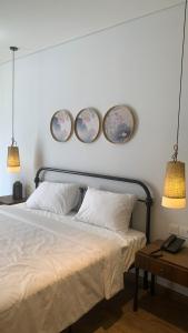 ein Schlafzimmer mit einem Bett mit vier Tellern an der Wand in der Unterkunft APEC Mandala Mũi Né Condotel in Ấp Thiẹn Ái