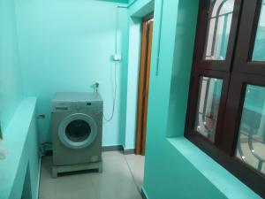 lavadora en una habitación con ventana en casa bon souvenirs, en Pondicherry