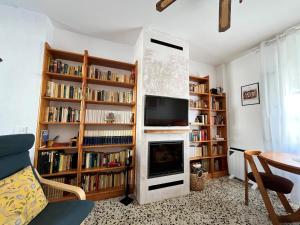 a living room with a fireplace and book shelves at Casa Morería in Guadalcanal