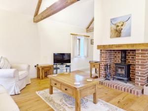 uma sala de estar com uma lareira de tijolos e uma mesa em The Run, West Lavant em Chichester