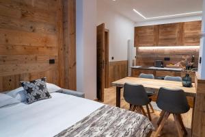a bedroom with a bed and a table and chairs at Fior di Roccia Apartments- in centro Cervinia, sauna privata, Matterhorn dream in Breuil-Cervinia