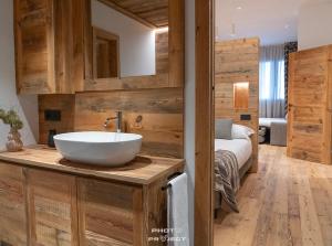 a bathroom with a sink and a bed in a room at Fior di Roccia Apartments- in centro Cervinia, sauna privata, Matterhorn dream in Breuil-Cervinia