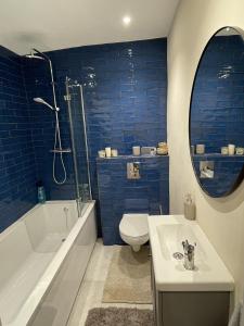 La salle de bains est pourvue de toilettes, d'une baignoire et d'un lavabo. dans l'établissement Globe Apartments, à Glastonbury