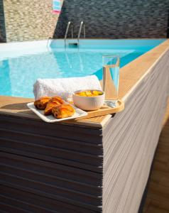 ein Tablett mit Essen auf einem Tisch neben einem Pool in der Unterkunft Studio jacuzzis et piscine au centre ville de Port-Louis in Port-Louis