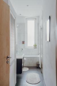 a white bathroom with a sink and a tub at NEU! Weinstraßenzauber Altbauwohnung mitten in NW in Neustadt an der Weinstraße