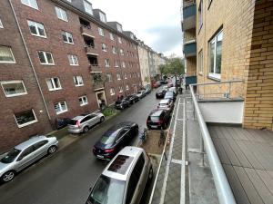 eine Reihe von Autos, die auf einer Stadtstraße geparkt sind in der Unterkunft Cozy apartment city nightlife in Düsseldorf