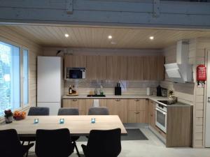 a kitchen with a table and chairs and a refrigerator at Koivuniemen Tila 3 in Säkylä