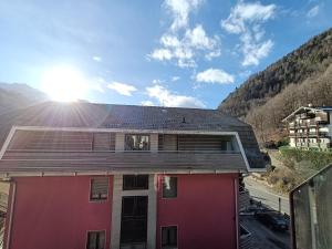 a house with the sun shining on the roof at Ak House in Aprica