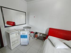 a room with a bed and a refrigerator in it at Hotel Oliveira in Goiânia