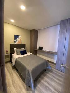 1 dormitorio con cama grande y pizarra en Apartamento cerca al Aeropuerto, en Bogotá