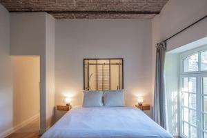- une chambre avec un grand lit et deux lampes dans l'établissement Domaine du Château de Haltinne-Maison du Jardinier, à Gesves
