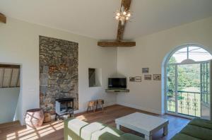 - un salon avec un canapé et une cheminée en pierre dans l'établissement Domaine du Château de Haltinne-Maison du Jardinier, à Gesves