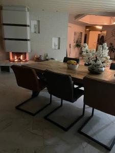 mesa de comedor con sillas y chimenea en Luxury Villa Stay en Waddinxveen