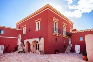 a large red building with stairs on the side at Antica Masseria le Monache in Grottaglie