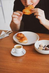 une personne assise à une table en train de manger une pâtisserie dans l'établissement Liiv Hub, à Natal