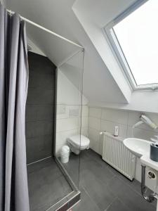 a bathroom with a shower with a toilet and a sink at Domizil in Bremen