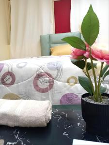MBZ - Pleasant Stay في أبوظبي: غرفة نوم بسرير وزرع على طاولة
