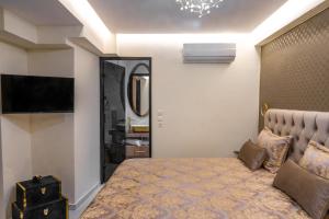 a bedroom with a large bed and a television at Odysseus Luxury House in Rhodes Town