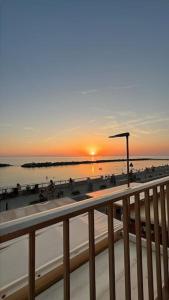 desde un balcón con vistas a la playa al atardecer en Casa Vacanze Marina di Pisa Catola en Marina di Pisa
