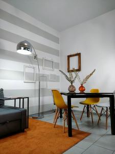 una sala da pranzo con tavolo nero e sedie gialle di Elegant Smart Suite with Free Parking a Torino