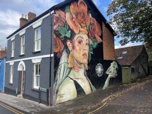 a painting of a woman with flowers on the side of a building at Globe Apartments in Glastonbury
