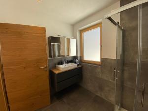 a bathroom with a sink and a glass shower at Ferienwohnungen Moser in Steinberg am Rofan +42 photos